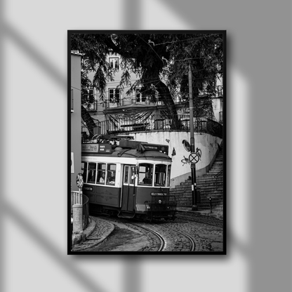 A black and white photograph of a tram on a city street, framed in a black frame with a glass overlay.